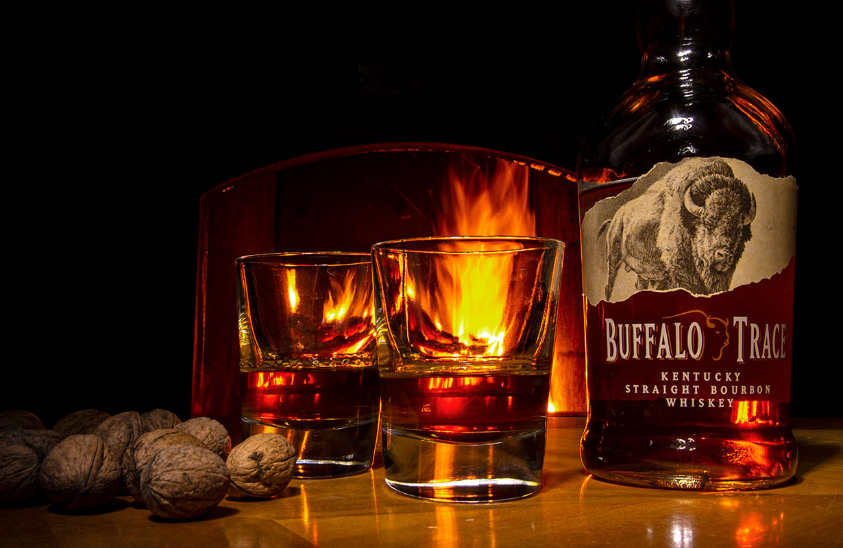 Whiskey mit Gläsern im Hintergrund Kaminfeuer